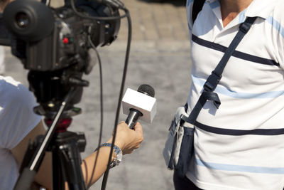 Midsection of reporter taking interview of man