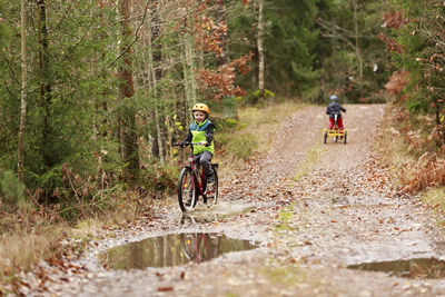 Boy cycling through forest