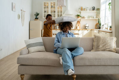 Woman sitting on sofa at home