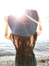 Rear view of woman on beach against sky