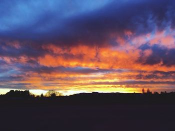 Scenic view of dramatic sky over silhouette landscape