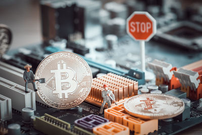 Close-up of bitcoins with figurines on circuit board