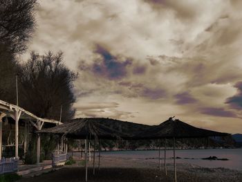 Built structure by lake against sky during sunset