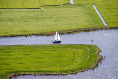 High angle view of green boat on river amidst farms