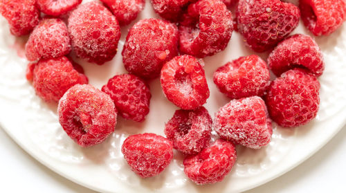 Full frame shot of frosen raspberries in white plate