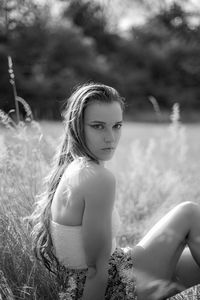 Portrait of beautiful young woman sitting in grass 
