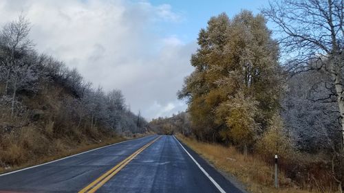 Road amidst trees against sky