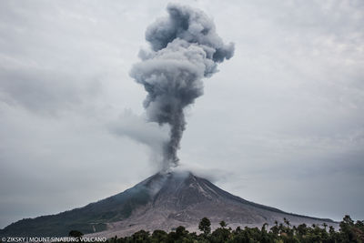 Smoke emitting from volcanic mountain against sky