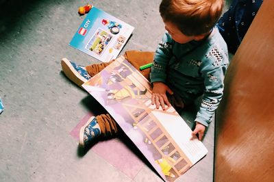 High angle view of boy sitting on floor
