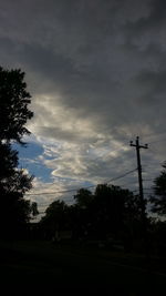 Silhouette of trees against cloudy sky