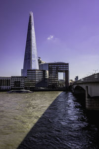 Bridge over river against buildings in city