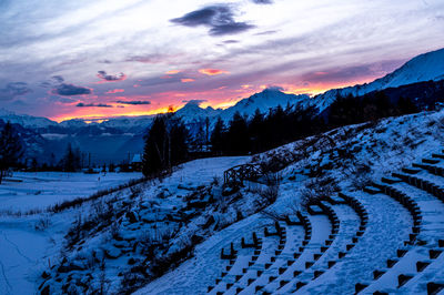 Scenic view of snow covered field against sky at sunset
