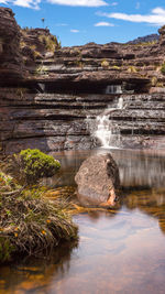 Scenic view of waterfall against sky