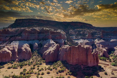 Rock formations on landscape against sky during sunset