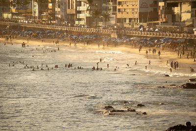 people are seen during strong sun on praia da barra in the city of salvador, bahia.