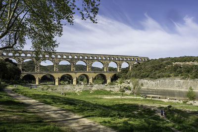 Arch bridge over river against sky