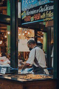 Rear view of man standing at store