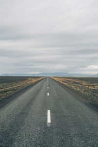 Road passing through landscape against sky