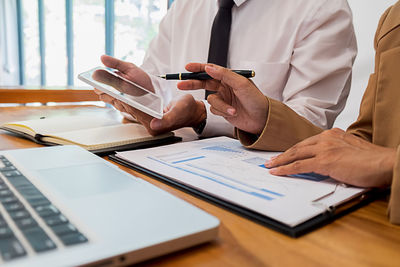 Midsection of man using laptop on table