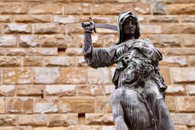 Low angle view of statue against wall