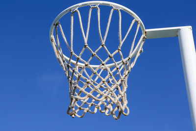 Low angle view of basketball hoop against clear blue sky