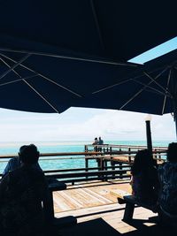 Rear view of people looking at sea against sky