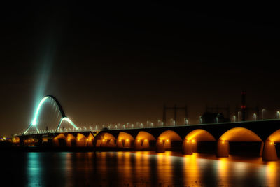 Low angle view of bridge over river at night