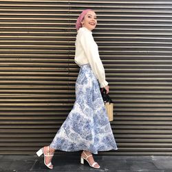 Smiling woman standing against shutter