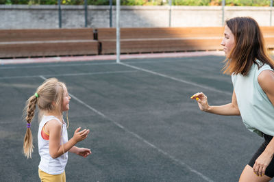 Side view of young woman playing tennis