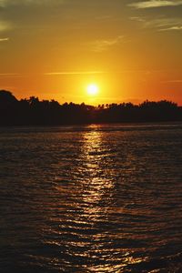 Scenic view of sea against dramatic sky during sunset