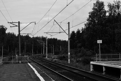 Railroad tracks by trees against sky