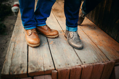 Low section of man standing on hardwood floor