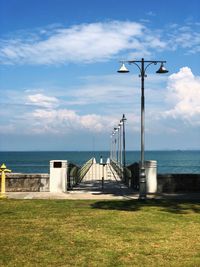 Street light by sea against sky