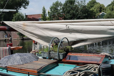 Boats moored by lake against trees