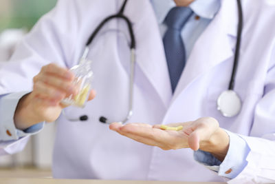 Asian doctor capsules pill in a glass bottle into of your hand