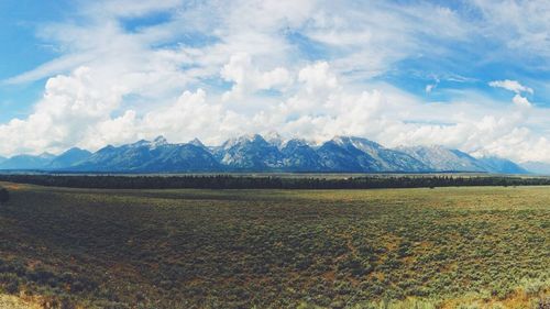 Scenic view of field and mountains against sky