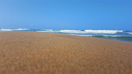 Scenic view of beach against blue sky