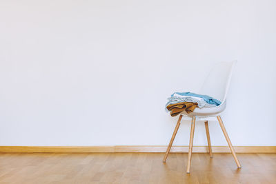 Empty chair on hardwood floor against wall