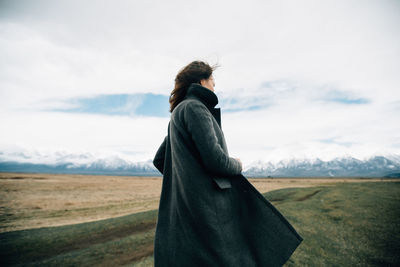 Woman standing on field against sky