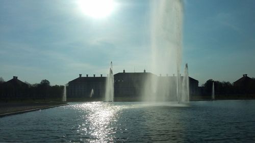 Fountain in city against sky