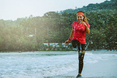 Portrait of young woman with umbrella in rain