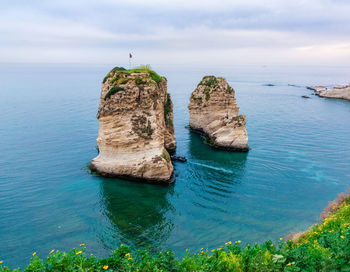 Rock formations in sea against sky