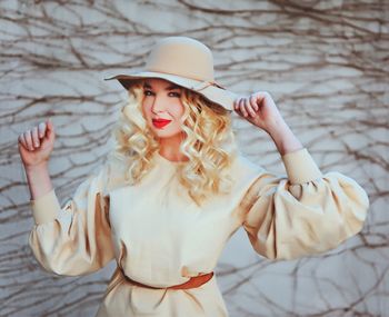 Portrait of young woman wearing hat standing outdoors