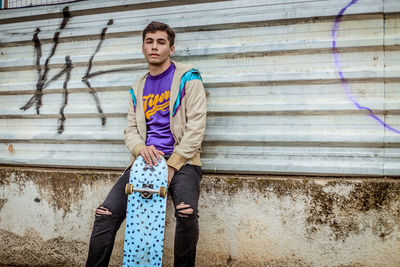 Portrait of teenage boy standing against wall