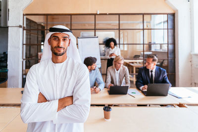 Portrait of young woman standing in office