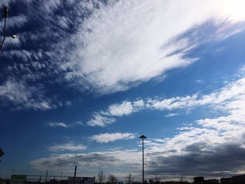 Low angle view of silhouette communications tower against blue sky