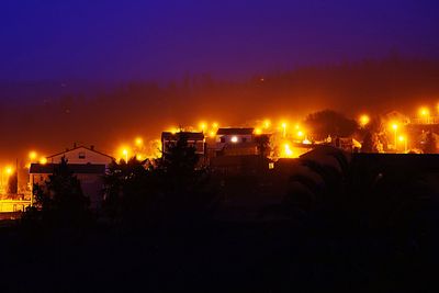 Illuminated city against sky at night