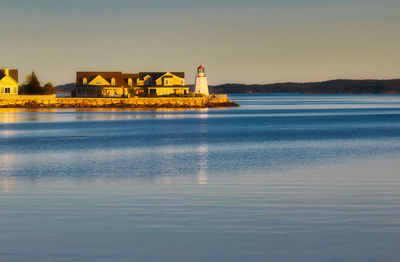 Scenic view of sea by buildings against sky