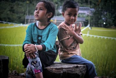 Side view of a boy sitting on grassland