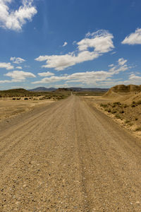 Tire tracks on road against sky